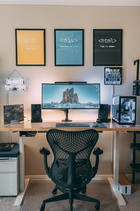 Bureau moderne avec écran, chaise et décoration murale.