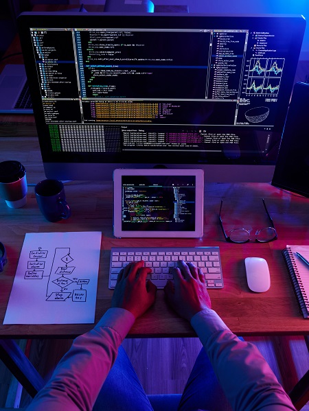 Développeur écrivant du code sur ordinateur.
